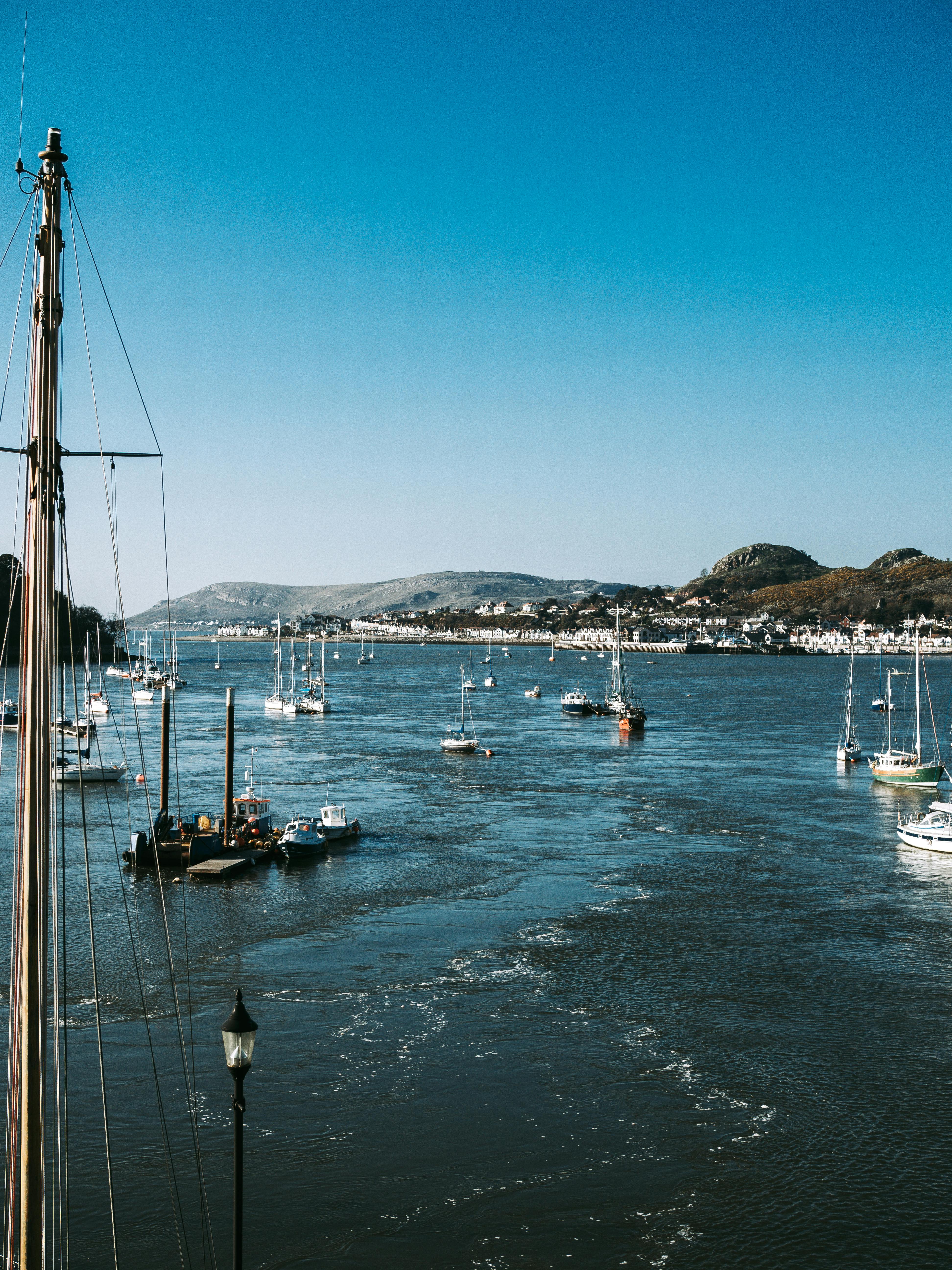 Free A serene view of sailing boats on the Conwy Estuary with hills in the background. Stock Photo