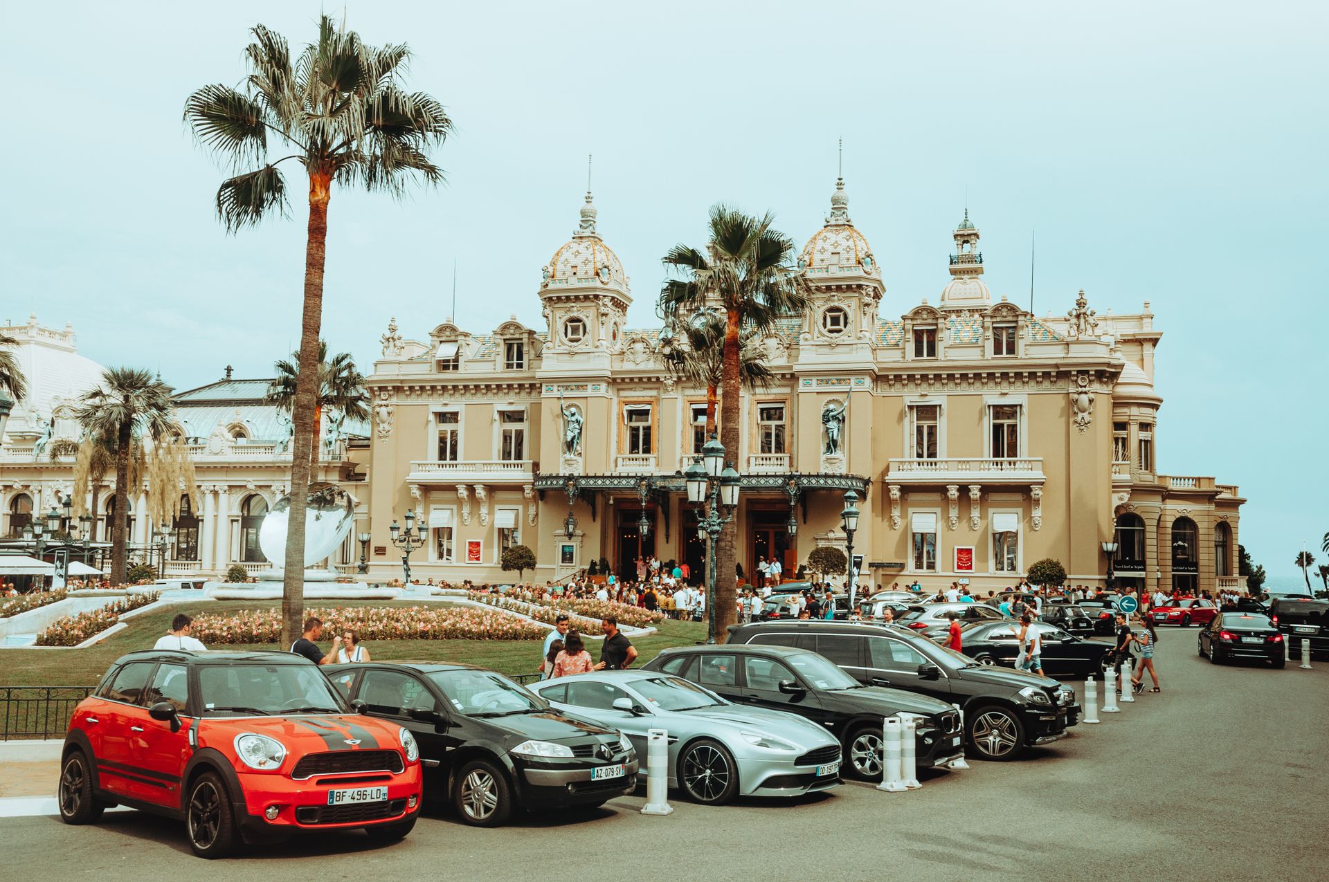 Cars parked in front of Monte Carlo Casino, a blend of luxury and architectural grandeur.