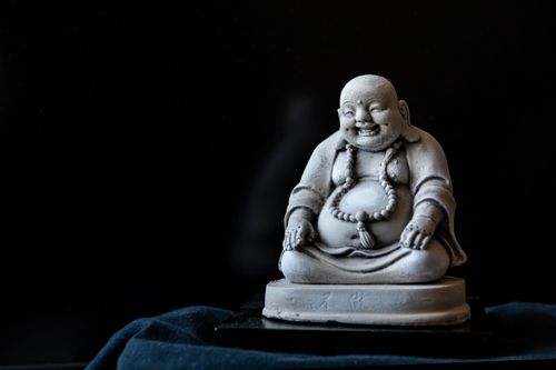 Free A serene Buddha figurine captured in a dark, minimalist setting, conveying peace and tranquility. Stock Photo