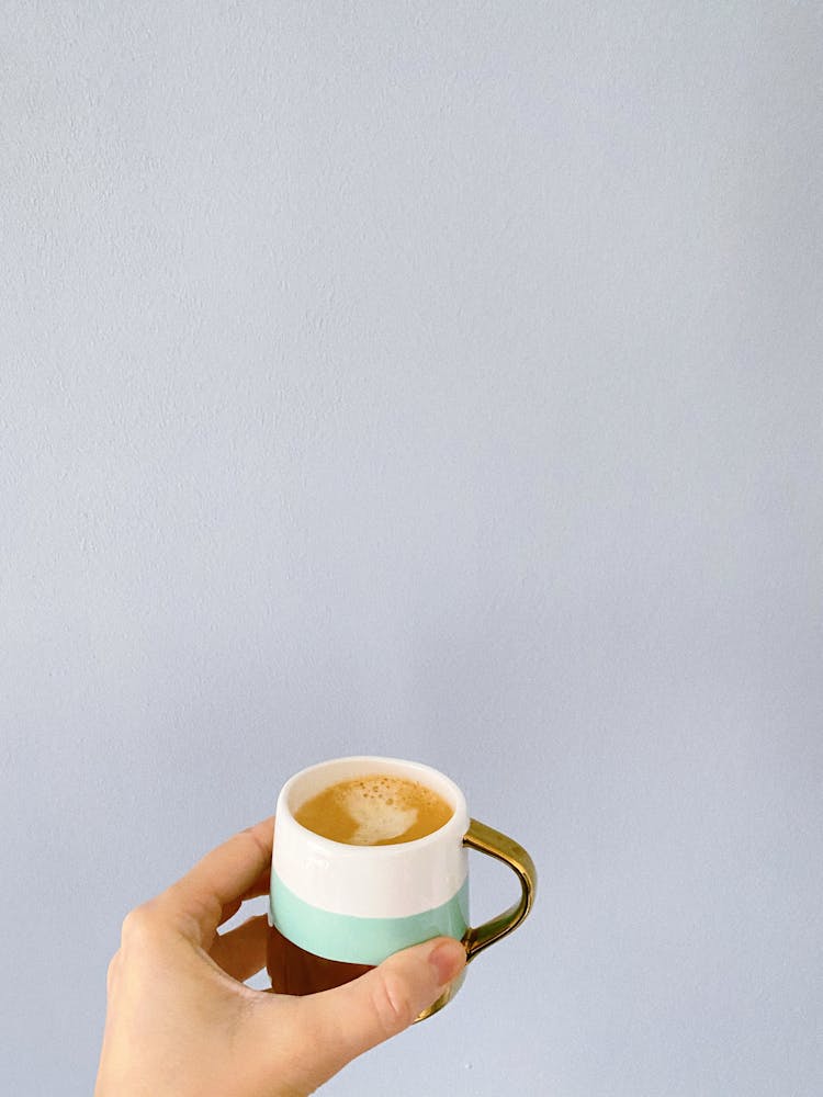 Hand Of Woman With Cup Of Hot Coffee With Milk