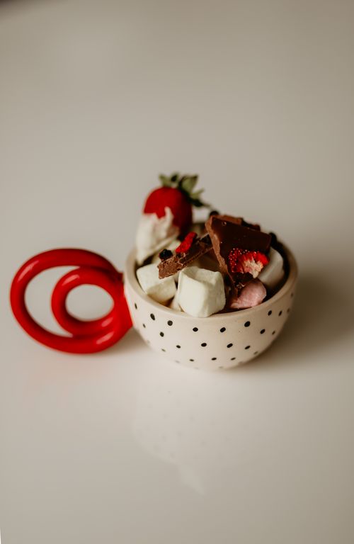 Free Decorative ceramic cup with assorted chocolates and strawberries, perfect for sweet indulgence. Stock Photo