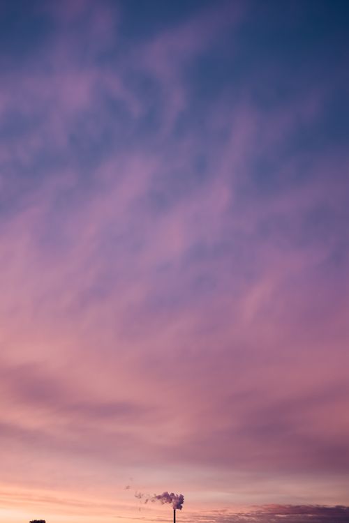 Free Bright sky with clouds in smoke coming out of tall industrial pipe placed on street of city at sunset time Stock Photo