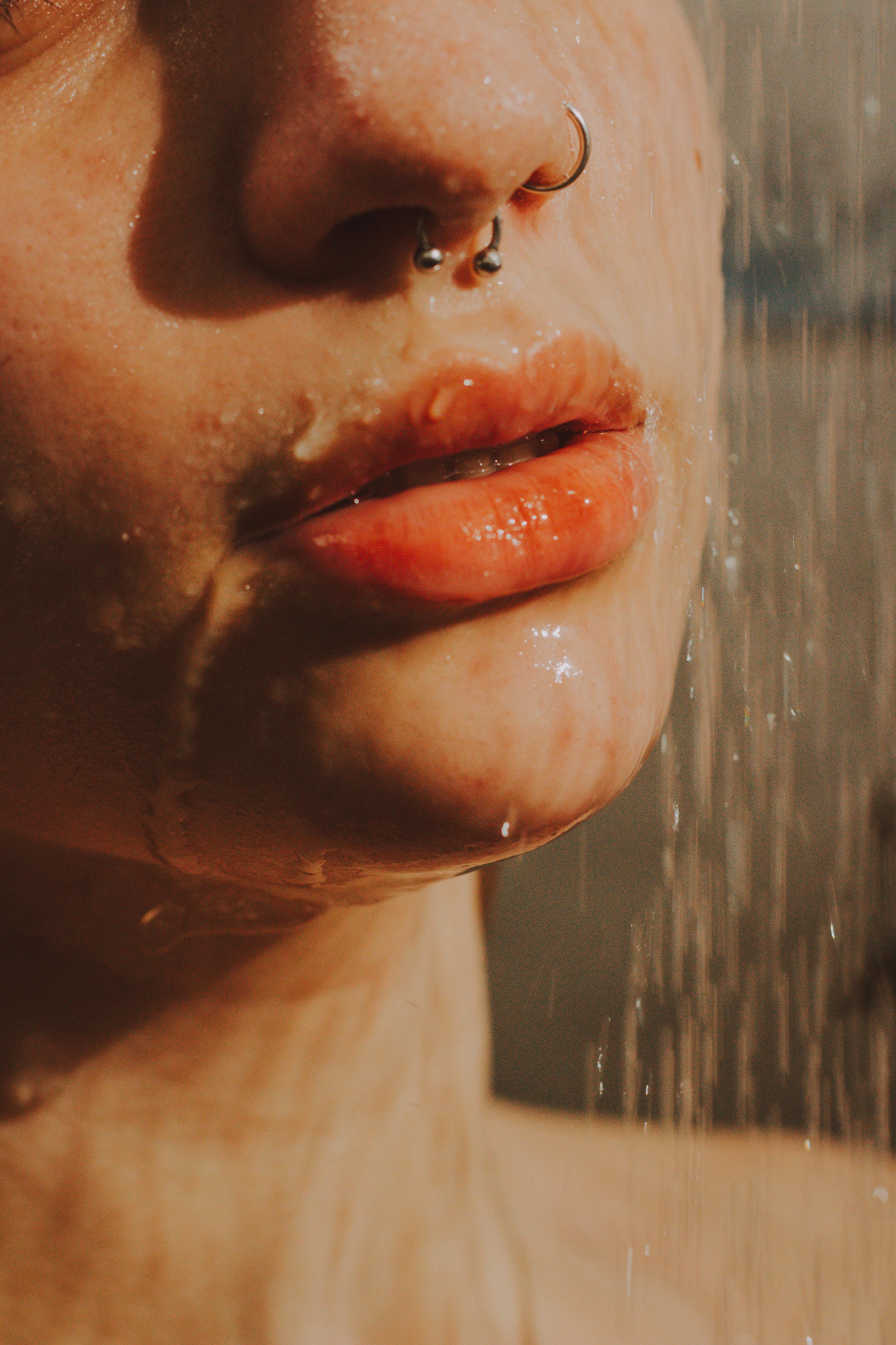 a woman with nose piercings taking a shower