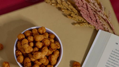 Top View of Snacks and a Book on a Beige Table