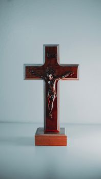 A wooden crucifix depicting Jesus Christ against a plain white background.