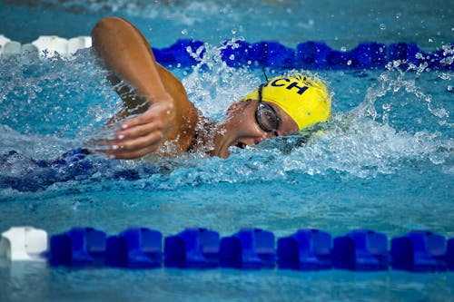 無料 スイミングプールで黄色の水泳帽をかぶっている人 写真素材