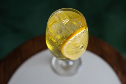 Free A refreshing citrus drink with ice cubes served in a wine glass, perfect for a hot day. Stock Photo