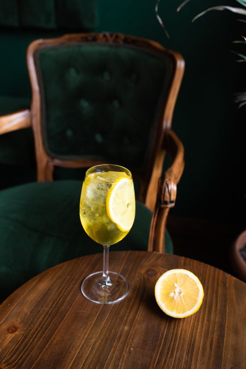 Free A refreshing lemon cocktail in a glass with ice, set on a rustic wooden table indoors. Stock Photo