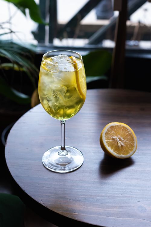 Free Chilled citrus cocktail with lemon slice on wooden table, perfect for a refreshing drink. Stock Photo