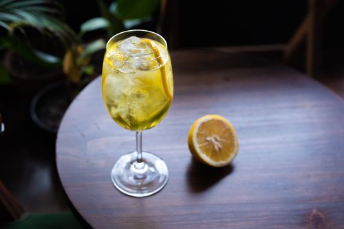 Free Refreshing citrus drink with ice in a goblet on a wooden table, perfect for summer. Stock Photo