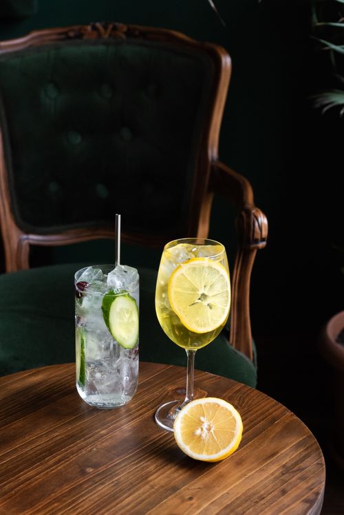 Free Elegant cocktails with lemon and cucumber slices on a wooden table, evoking a refreshing summer vibe. Stock Photo