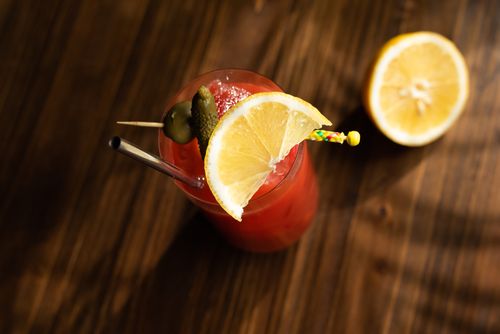 Free Top view of a vibrant cocktail garnished with a lemon slice on a wooden table. Stock Photo