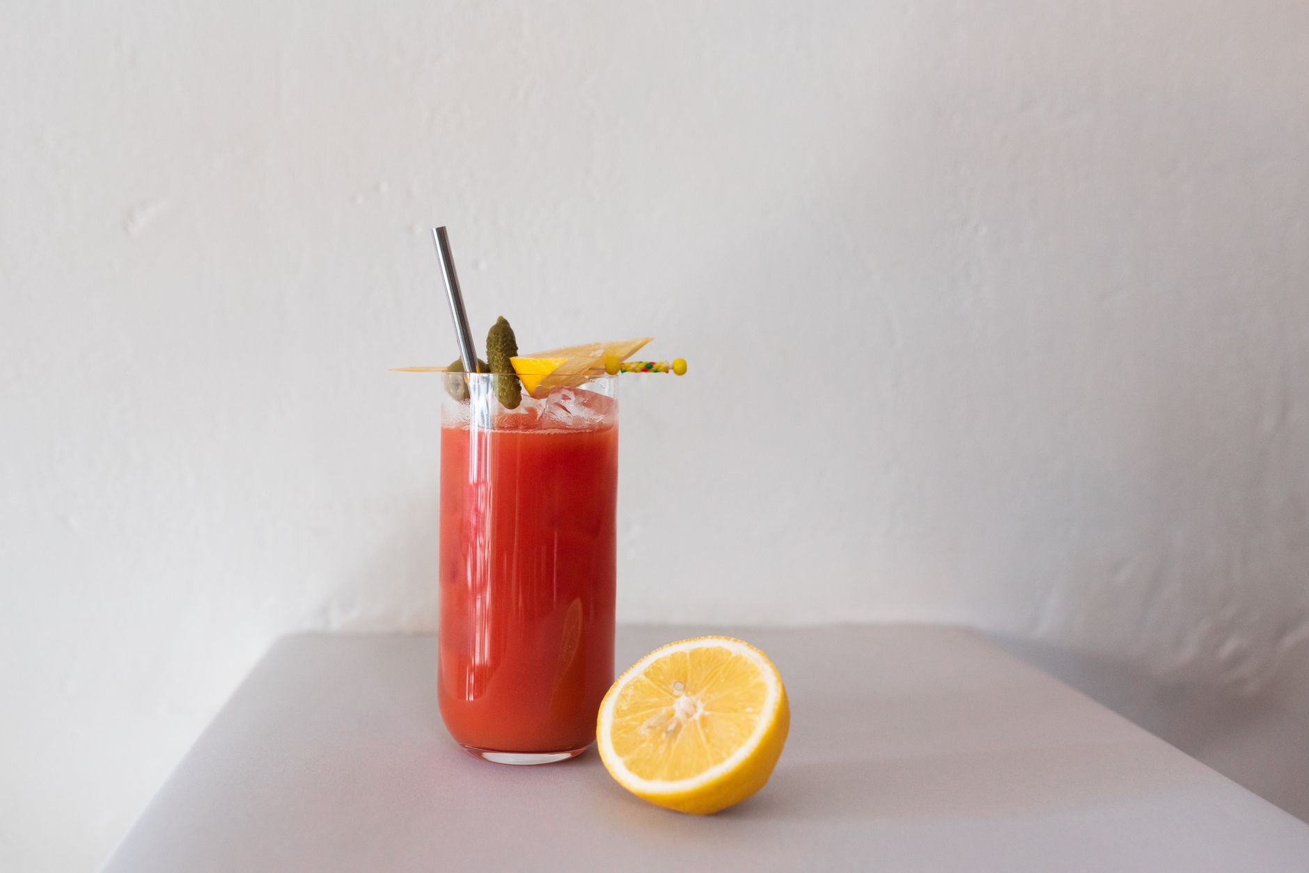 Dirty Bloody Mary cocktail garnished with olive, cherry tomato, and pepperoncino
