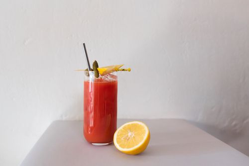 Free Close-up of a Bloody Mary cocktail with a lemon slice garnish on a minimalist background. Stock Photo