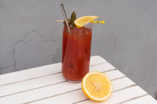 Free Close-up of a bloody mary cocktail with lemon slice on a white table. Stock Photo