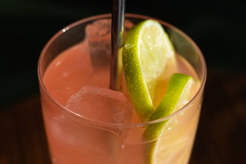 A Pink Alcoholic Drink with Lime Slices