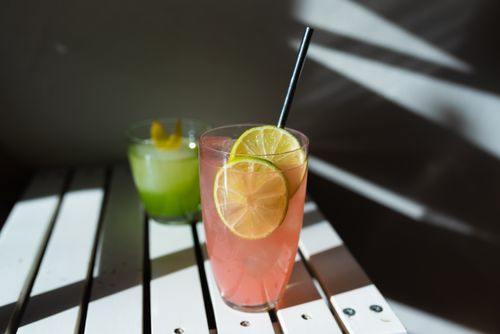 Free Vibrant cocktails with lime garnish on a sunlit table, perfect for refreshing summer vibes. Stock Photo
