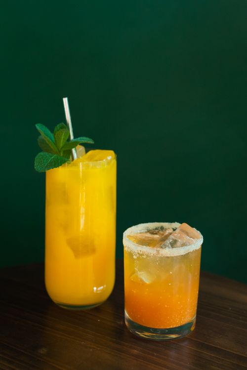 Free Two citrus cocktails with mint leaves against a dark green background, perfect for summer. Stock Photo