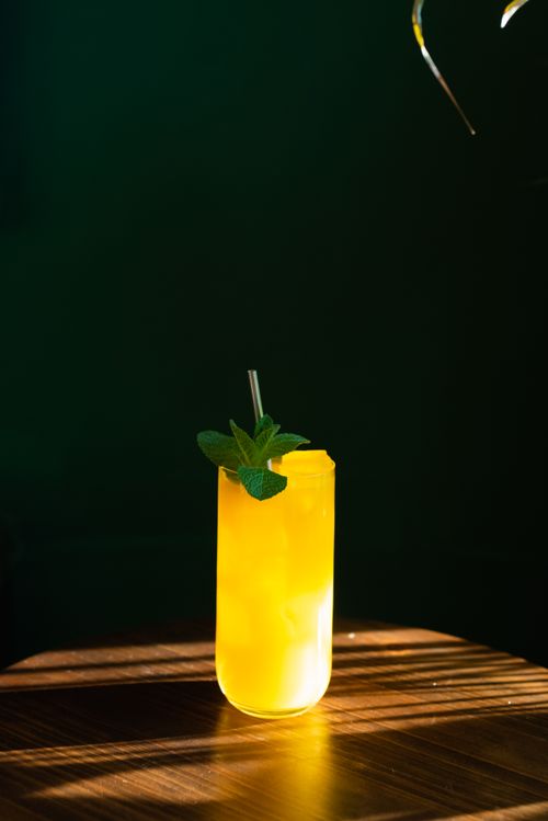 Free Sunny citrus cocktail with mint and ice in a glass on a wooden table. Stock Photo