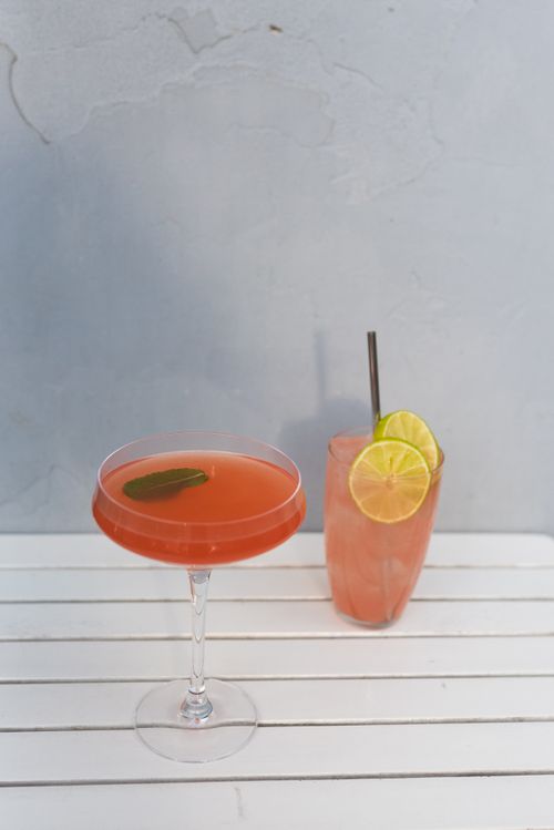 Free Chilled summer cocktails on a white table, featuring lime garnish. Perfect for refreshment. Stock Photo