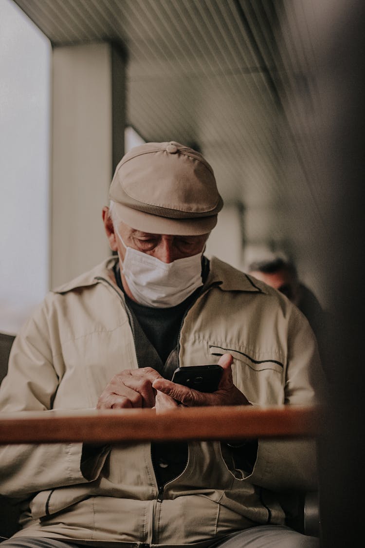 Man In Brown Overall Using A Cellphone