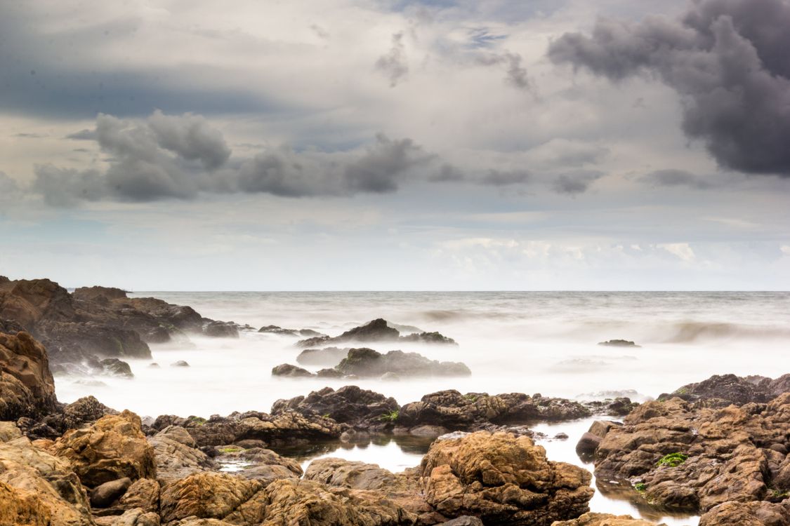 Seascape Rocks Brown Brown Rocks on Sea Shore Under Cloudy Sky · Free Stock Photo