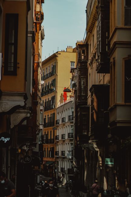 Discover a narrow urban alley lined with charming apartment buildings in a European city.
