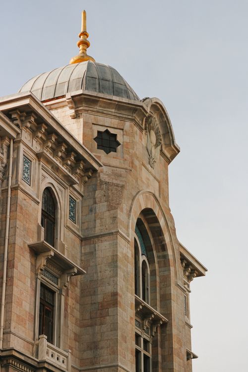 Free Detailed view of a historic stone building featuring a dome roof and arched windows. Stock Photo