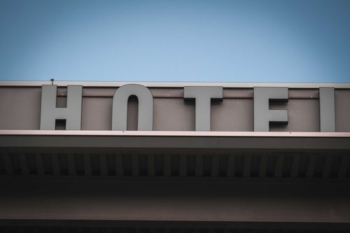 Free From below fragment of exterior of modern building with Hotel signage against cloudless blue sky in city Stock Photo