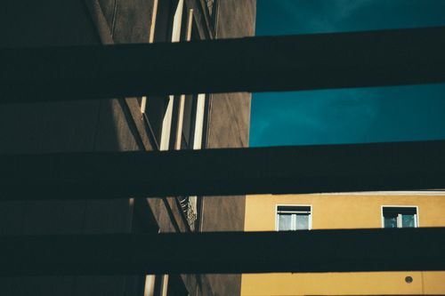 Free From below of fragment of aged residential building at sunny day viewed through window blind Stock Photo