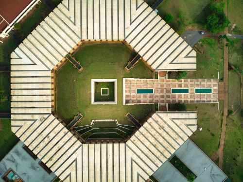 Free Stunning aerial drone shot of a hexagonal building in Yamoussoukro, Côte d'Ivoire. Stock Photo