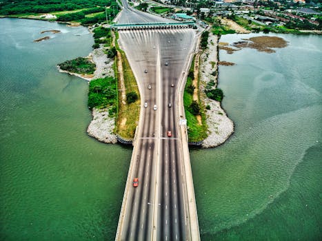 Aerial view of a busy bridge over a lake in Abidjan with motor vehicles in motion.
