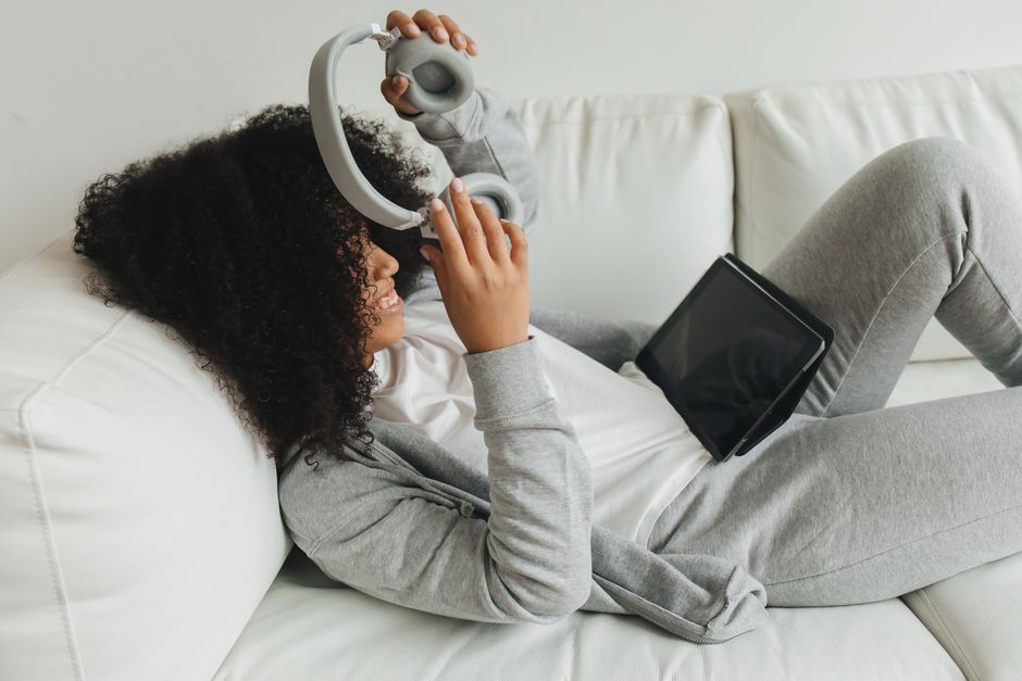 Tablet use with headphones while relaxing on a couch