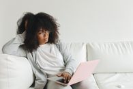 Woman in White Long Sleeve Shirt Sitting on White Couch