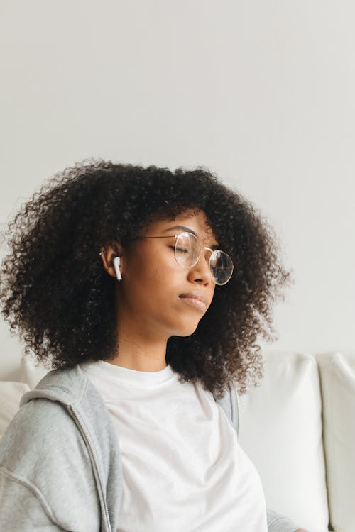 Free Woman in Gray Sweater Listening to Music Stock Photo