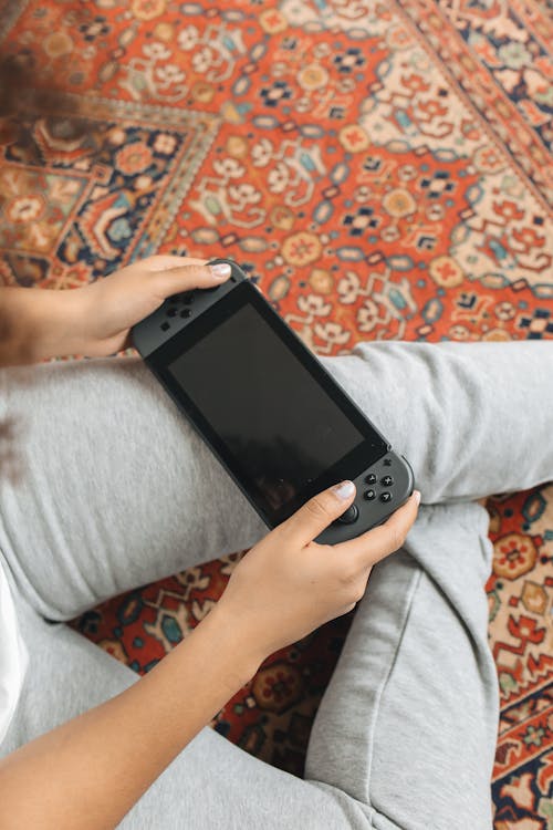 Free Person Holding a Video Game Console Stock Photo