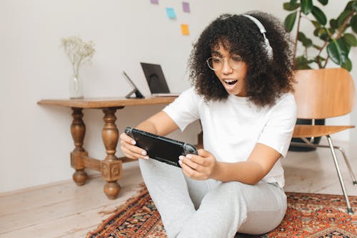 Woman Sitting on Floor while Playing Nintendo Switch