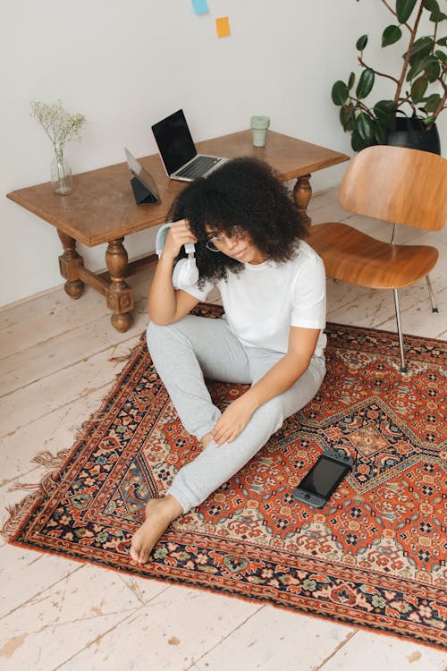 Woman in White T-shirt and Gray Pants Sitting on Floor