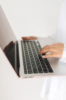Close-up view of hands using a laptop keyboard. Ideal for tech and lifestyle themes.
