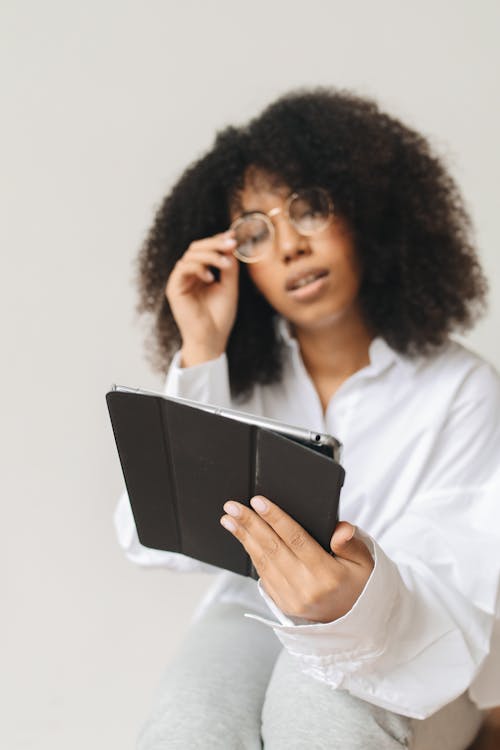 Free Woman Wearing Eyeglasses Holding a Tablet Stock Photo