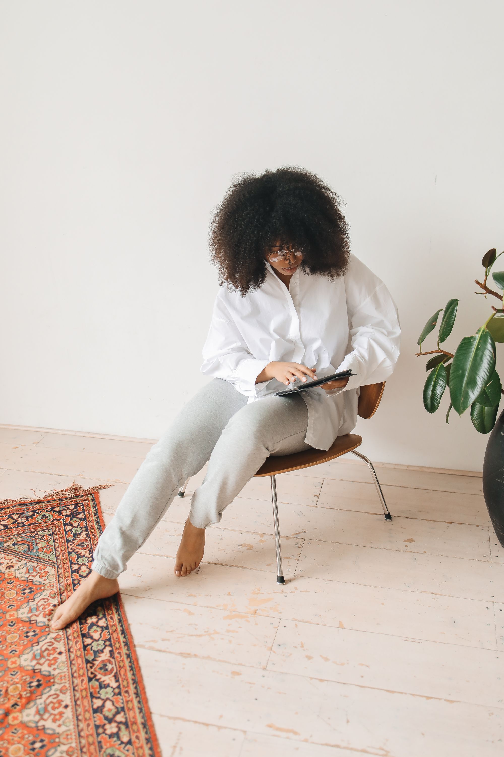 A Woman Sitting on a Chair Using a Tablet · Free Stock Photo
