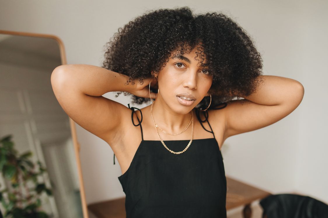 Woman in Black Dress Wearing Her Necklace · Free Stock Photo