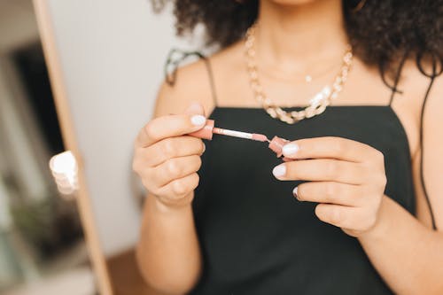 Woman in Black Dress Holding a Lipstick