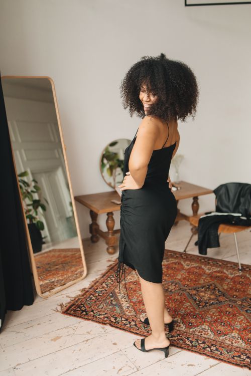 Free A stylish woman in a black dress poses confidently indoors, enhancing a modern aesthetic. Stock Photo