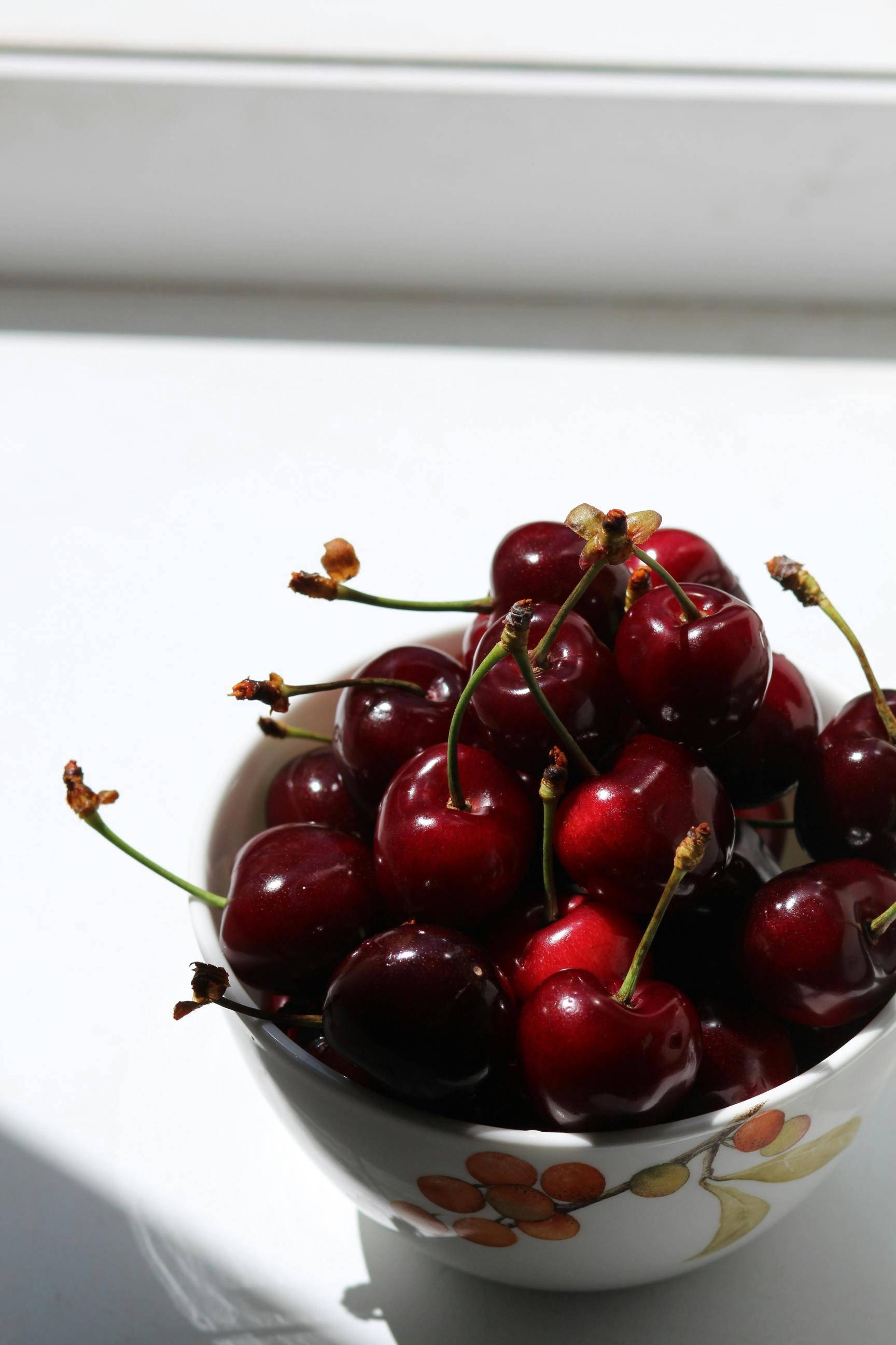 red cherries on white ceramic bowl