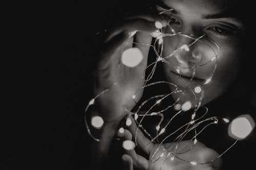 A Woman's Face Illuminated by String Lights