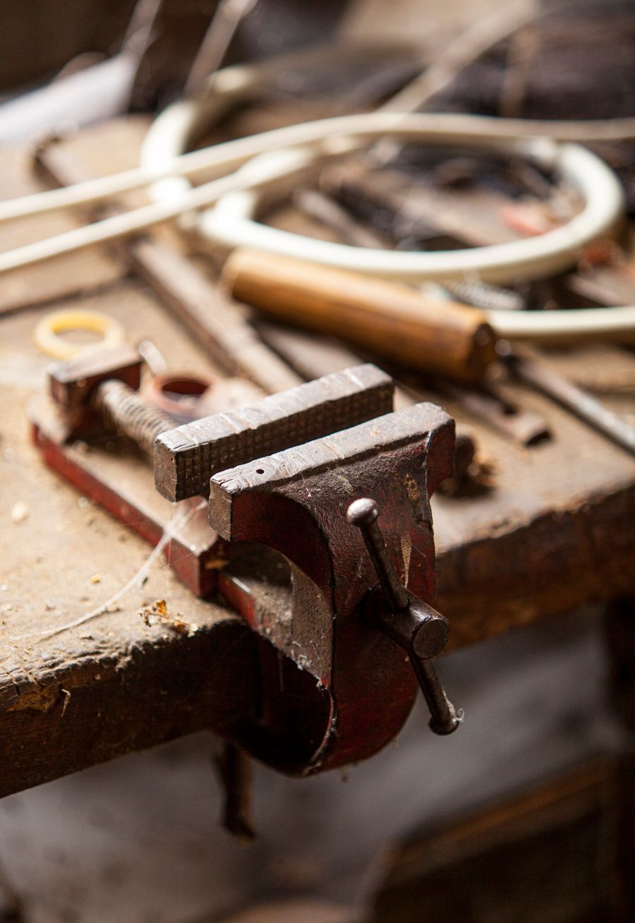 A bench vice and hand tools on a workshop bench, photo by Lars H Knudsen on Pexels