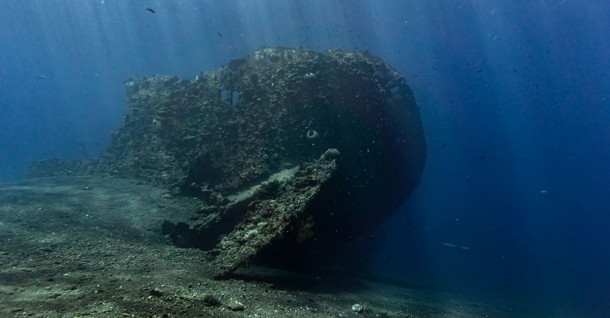 Explore an underwater wreckage surrounded by ocean marine life in Bali's deep blue sea.