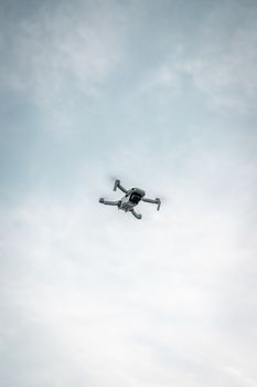 A drone quadcopter flying midair in a cloudy sky above Panama, capturing aerial views and photography.