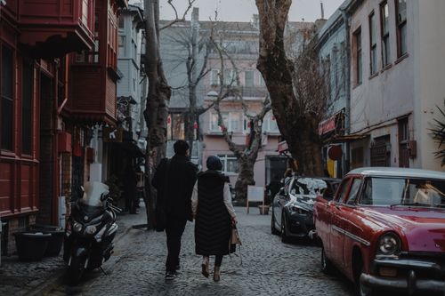 Free Man and woman walking on a cobblestone street in historic Istanbul, Turkey. Stock Photo